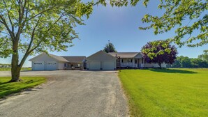A two-story house with a garage, a driveway, and a lawn.