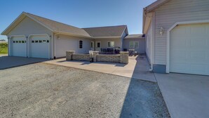 A two-story house with a driveway, garage, and outdoor seating area.