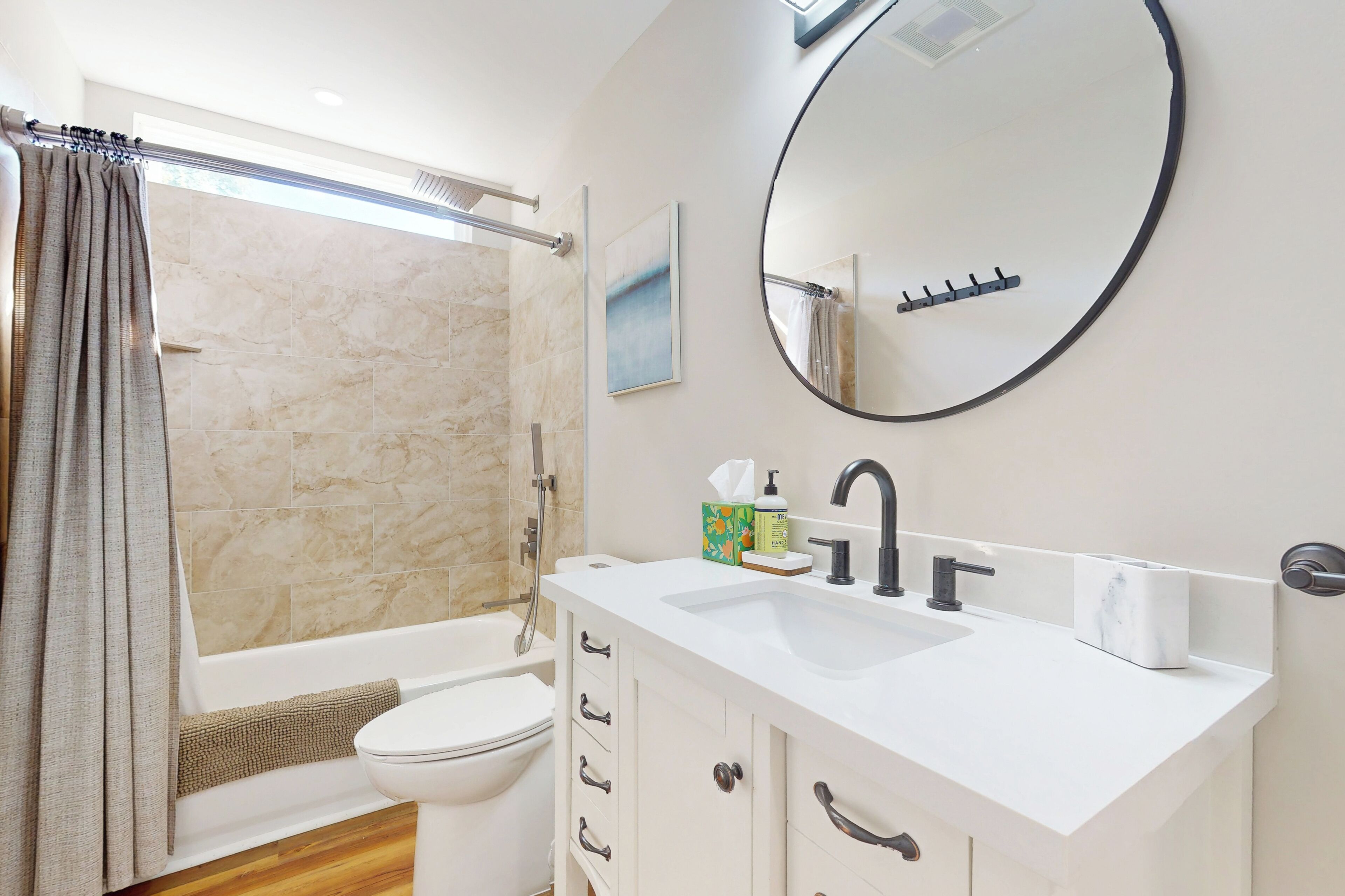 Een moderne badkamer met een bad, toilet en wastafel.