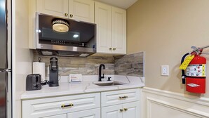 A kitchen with white cabinets, a stainless steel microwave, a coffee maker, and a fire extinguisher. - Nurse-ready Studio Retreat! 2 Mi to Dtwn Holyoke (Holyoke)