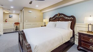 A neatly made bed with a wooden headboard, a ceiling fan, and a nightstand with a lamp. - Nurse-ready Studio Retreat! 2 Mi to Dtwn Holyoke (Holyoke)