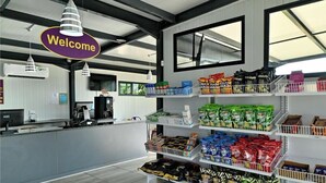 A modern retail store with a 'Welcome' sign, shelves stocked with snacks, and a counter area. - SleepOver Colesberg (Colesberg)