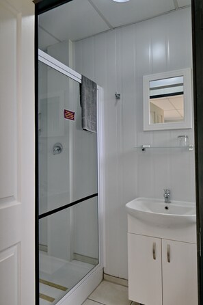 Regadera, amenidades de baño gratuitas, toallas, papel de baño