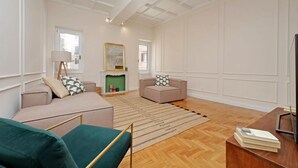 A spacious living room with a fireplace, two sofas, a coffee table, and a television. - Luxury home near Piazza Venezia (Roma)