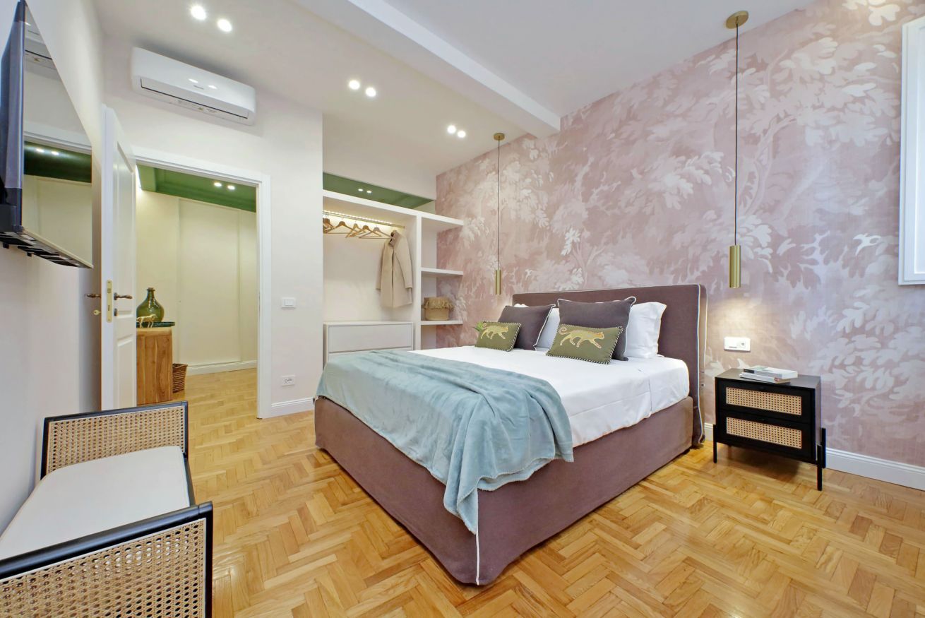 A bedroom with a bed, bedside table, and a wardrobe.