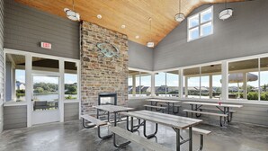 A spacious outdoor dining area with picnic tables and a stone wall, overlooking a scenic view. - 4 bed, 3 bath Single Family Home in Millville by the Sea: Community Pool, Fitness Center, Club house, Kayaking, Beach Shuttle, Free WIFI (Frankford)