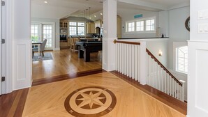 Een ruime keuken met houten vloeren, een centraal eiland en uitzicht op de eetruimte.