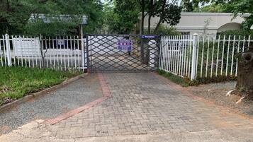 A gated entrance with a reception sign, a paved pathway, and a white fence.