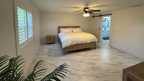 A bedroom with a bed, a ceiling fan, a nightstand, and a window with blinds. - Modern South Tampa Retreat steps off Bayshore blvd, the bay is a minute away (Tampa)