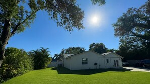 A two-story house with a well-maintained lawn and a clear blue sky. - Modern South Tampa Retreat steps off Bayshore blvd, the bay is a minute away (Tampa)