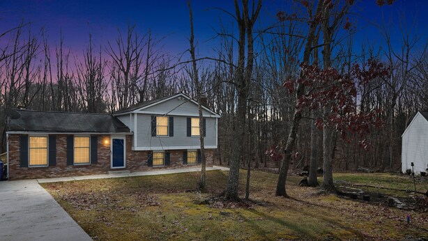A two-story house with a brick facade and a modern design, surrounded by a wooded area. - Manassas Comfort Cozy 3br Family Home 3 Bedroom Home (Manassas)