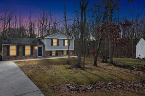 A two-story house with a brick facade and a modern design, surrounded by a wooded area. - Manassas Comfort Cozy 3br Family Home 3 Bedroom Home (Manassas)