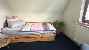 A small, cozy room with a loft bed, a small table, and a window. - Corner Haus RM1 (Schnaittach)