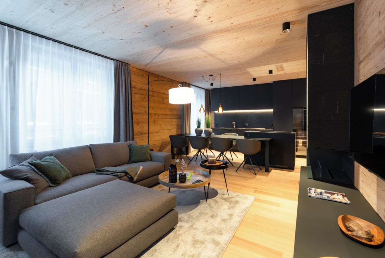 A modern living room with a sofa, coffee table, and dining area.