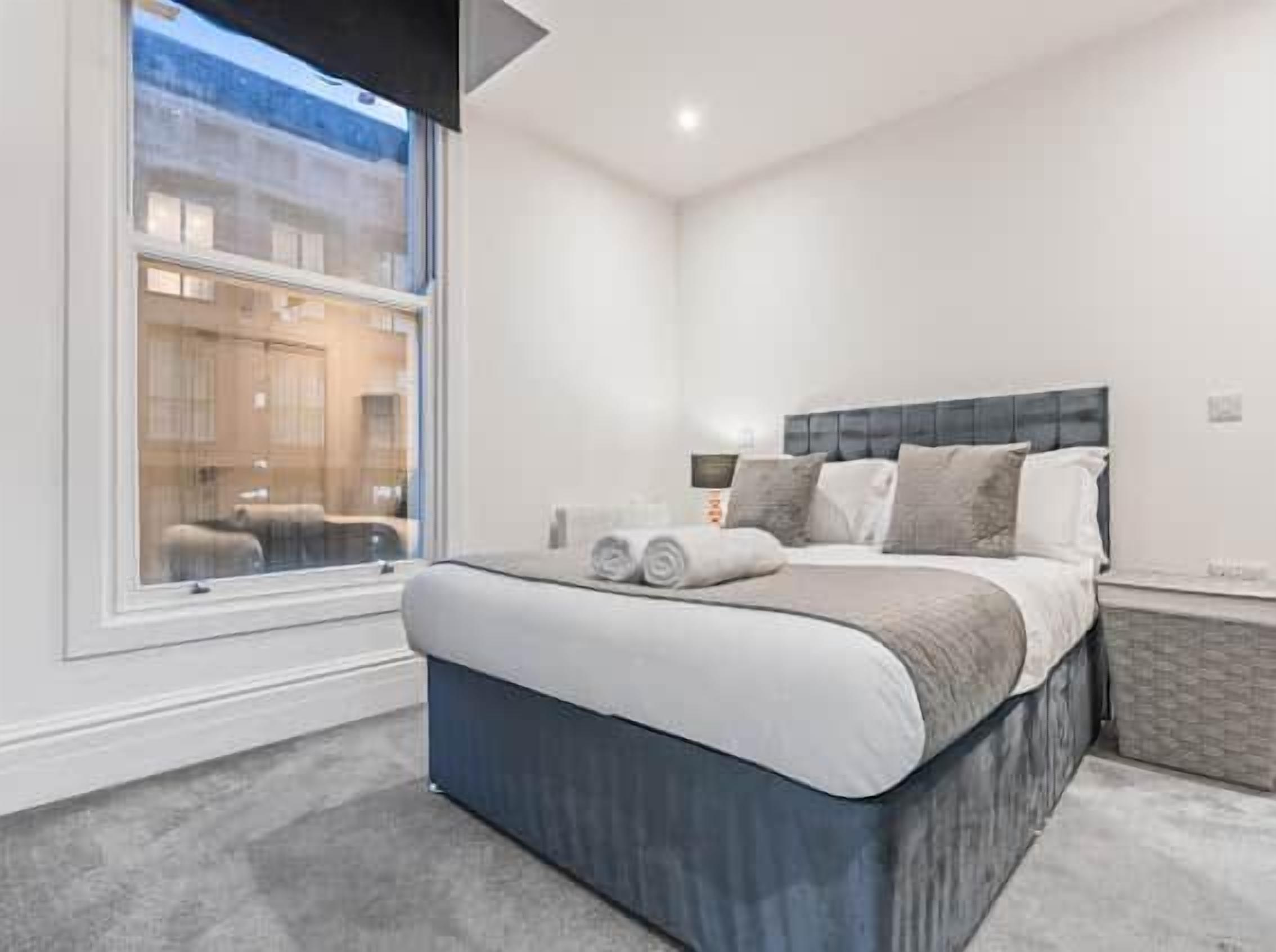 Une chambre moderne avec un grand lit, une fenêtre et une vue sur l’extérieur.