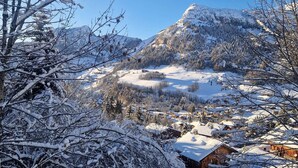 Eine verschneite Berglandschaft mit einem Dorf im Tal.
