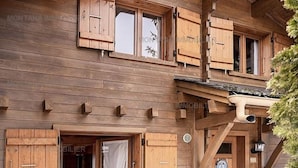 Ein hölzernes Gebäude mit mehreren Fenstern und einer Tür, das einen traditionellen Baustil zeigt.