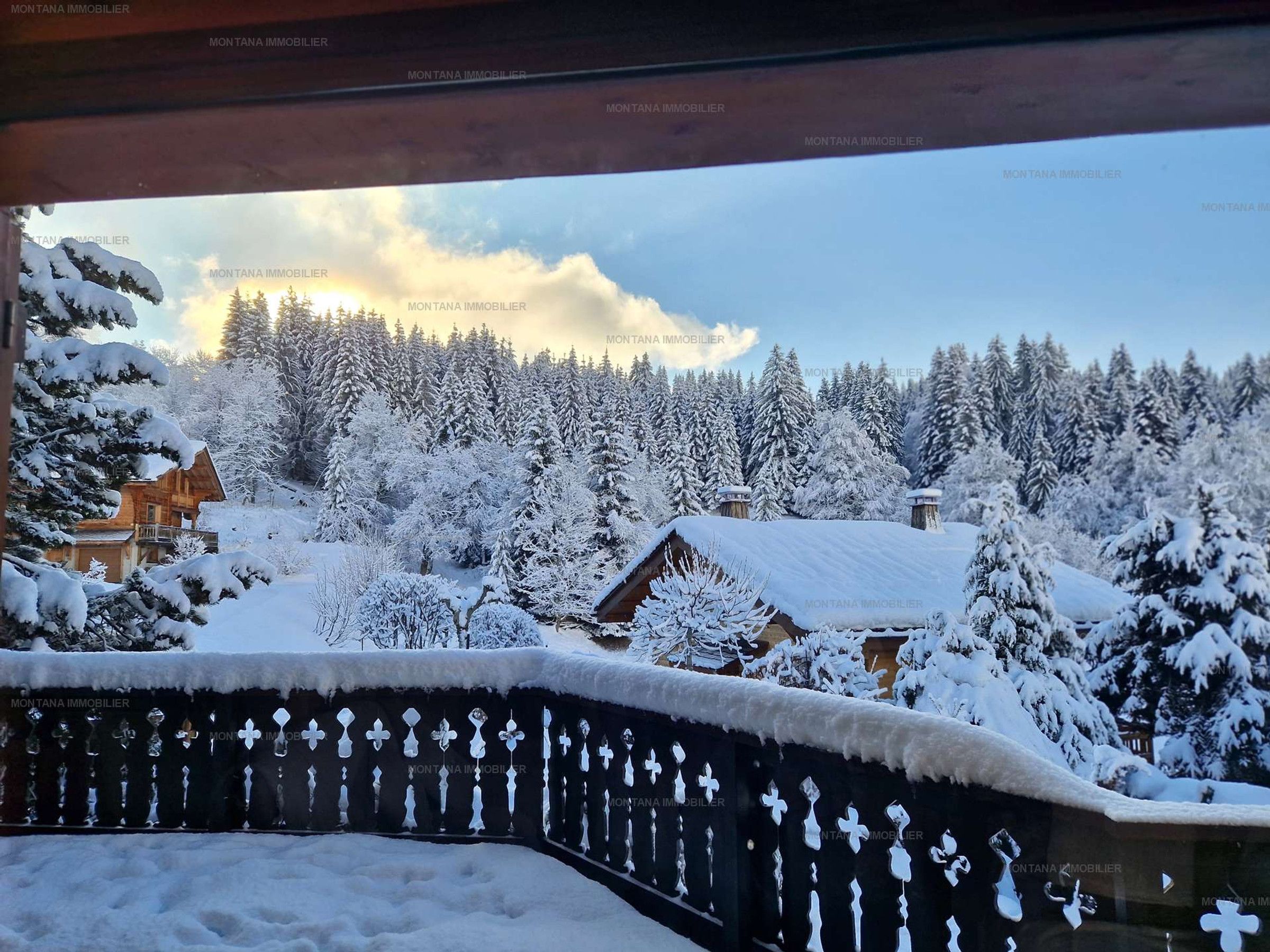 A snowy landscape with a wooden cabin and a metal fence.