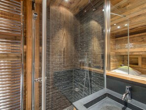 A modern bathroom with a glass shower enclosure, a wooden vanity, and a large mirror. - Apartment on the slopes with parking in Courchevel 1850 (Courchevel 1850)