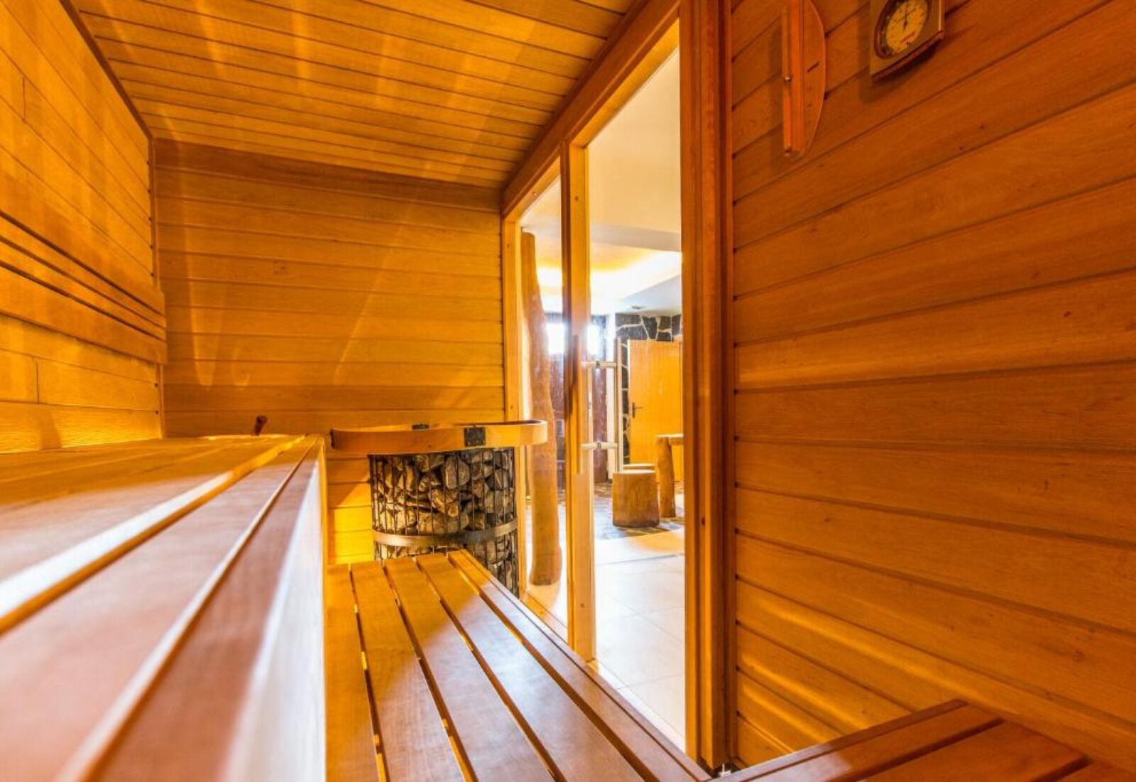 Interior de madera con bancos y una chimenea de piedra.