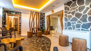 A lobby with stone walls, wooden furniture, and a modern ceiling design. - Hotel Franz - Rejvíz (Zlaté Hory)
