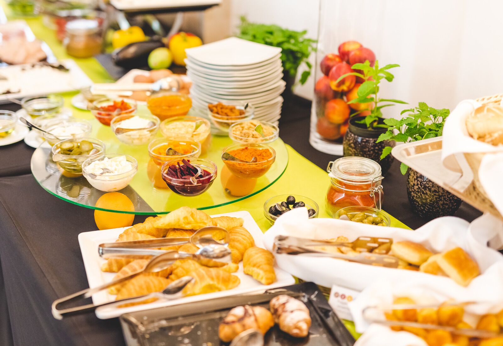 A buffet table with various food items and condiments.