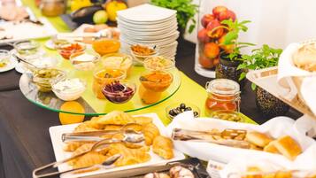 A buffet table with various food items and condiments.