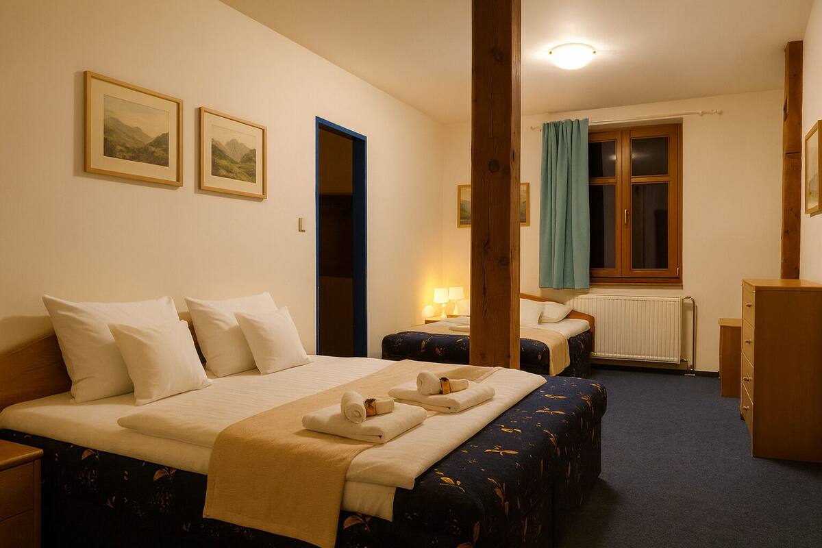 Habitación de hotel con una cama grande, dos camas más pequeñas, un armario de madera, un escritorio, una silla, una ventana con cortinas y dos cuadros en la pared.