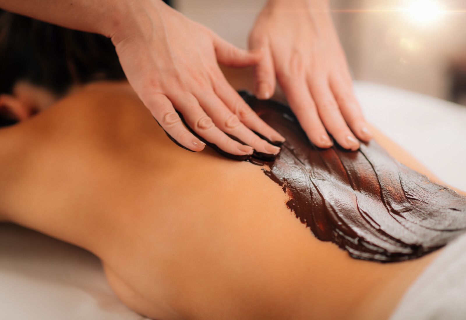 A massage being given to a person lying on a massage table.