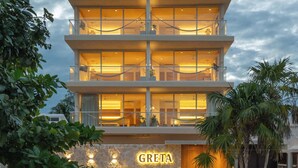 Un hôtel à plusieurs étages au design moderne, doté de balcons et de grandes fenêtres.