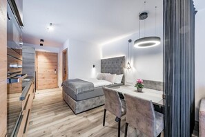 Une chambre à coucher moderne avec un lit, une table de chevet et un petit espace bureau.