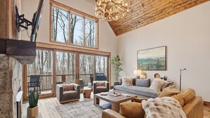 Un salon spacieux doté de grandes fenêtres, d’une cheminée et d’un coin salon confortable.