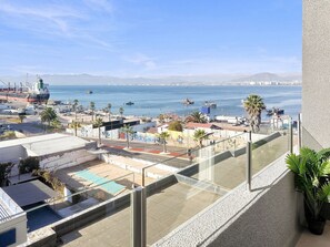 A balcony with a view of a port, ships, and distant mountains. - Oceana Suites Edificio HA (Coquimbo)