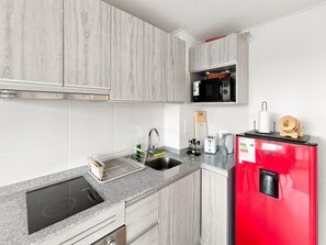 A modern kitchen with a built-in microwave, toaster, and water dispenser. - Oceana Suites Edificio HA (Coquimbo)