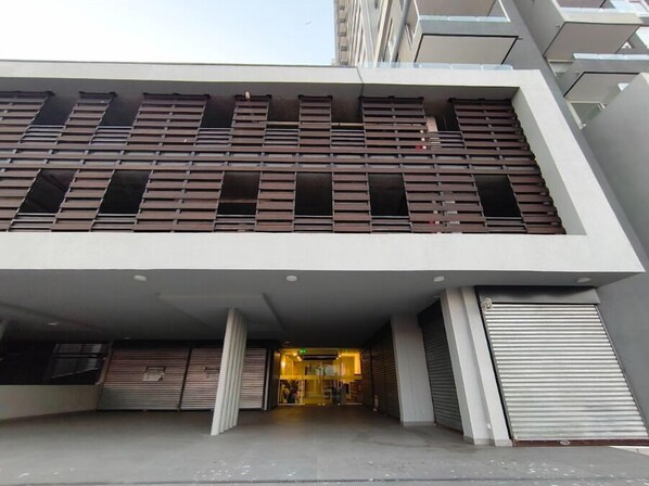 A modern building with a flat roof, large windows, and a covered entrance area.