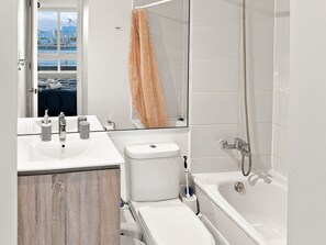 A modern bathroom with a bathtub, toilet, and sink. - Oceana Suites Edificio HA (Coquimbo)