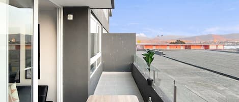 A balcony with a view of a cityscape and mountains.