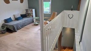 A bedroom with a bed, bedside table, and a window.