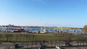 A marina with boats docked, a parking area, and a clear sky. - Pure relaxation on the Baltic Sea: vacation apartment with sandy beach right on the doorstep! (Fehmarn)