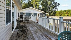 A wooden deck with a white railing, a table, and chairs. - Wonderful 3-bedroom house with AC in welcoming Cross Hill (Cross Hill)