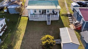 A single-story house with a front porch, a small attached garage, and a fenced yard. - Wonderful 3-bedroom house with AC in welcoming Cross Hill (Cross Hill)