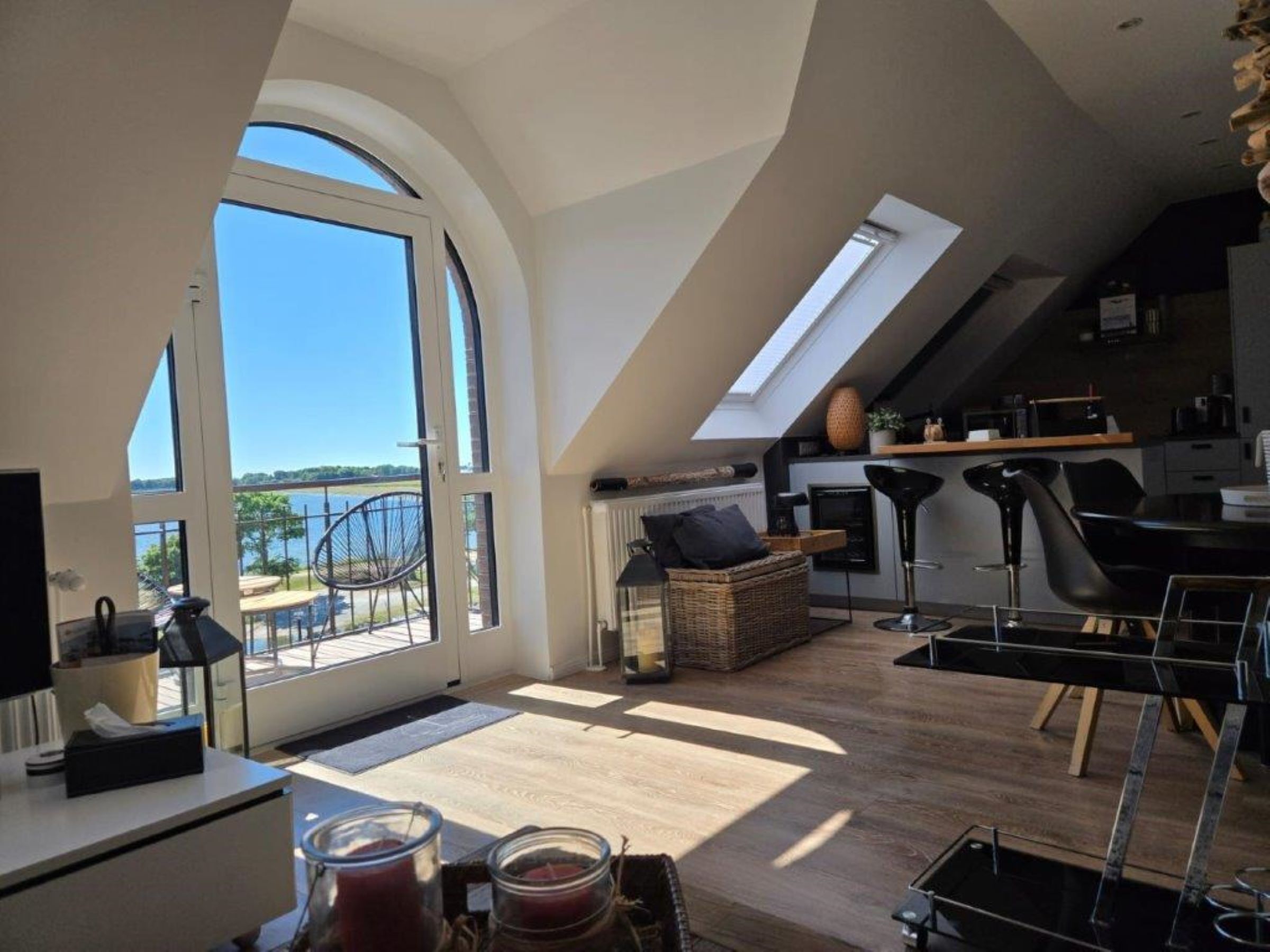 A spacious loft with a large skylight, a dining area, and a kitchen.