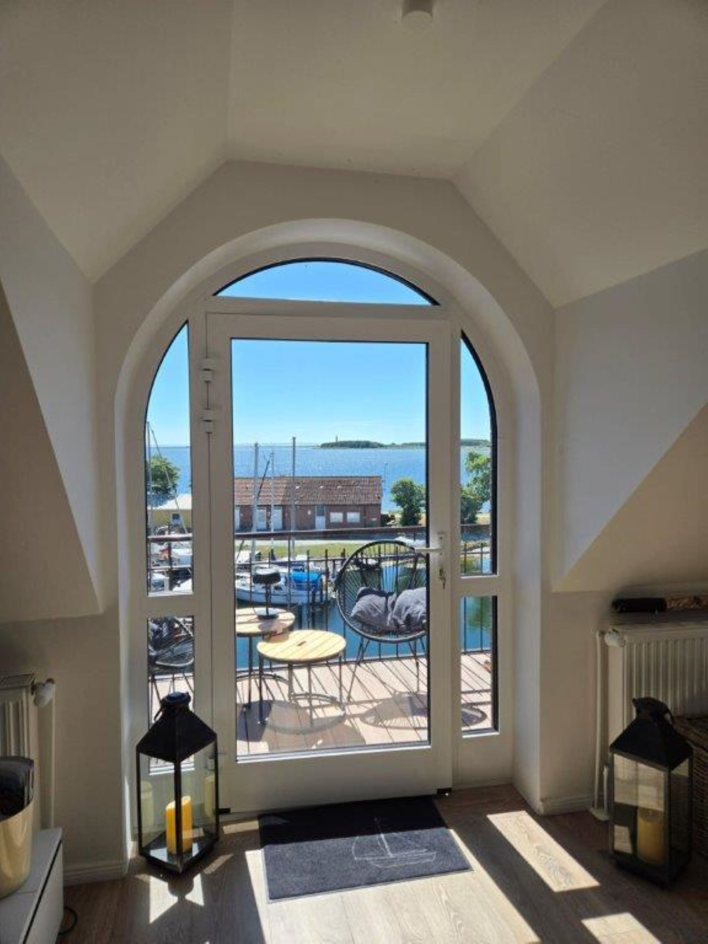 A room with a large arched window overlooking a pool area.