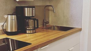 Eine moderne Küche mit Edelstahlgeräten, Holz Arbeitsplatten und weißen Schränken.