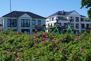 Ein Wohngebäude mit Balkon und einem Fahrrad davor.