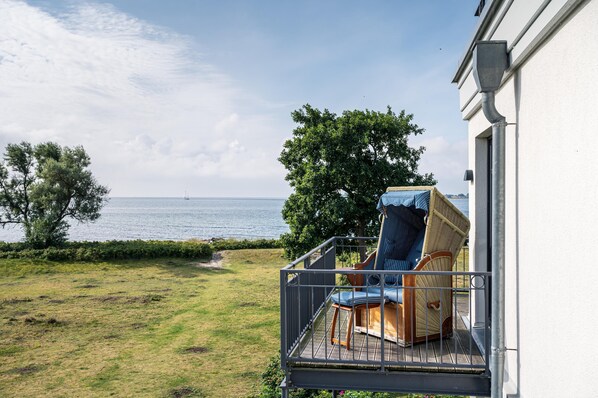 Ein Balkon mit Meerblick, ein Stuhl und ein Tisch.
