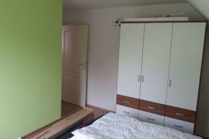 Ein Schlafzimmer mit einem Bett, einem Kleiderschrank und einer Tür.