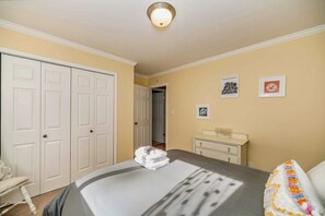 Ein Hotelzimmer mit Bett, Stuhl, Kommode und einer Tür.