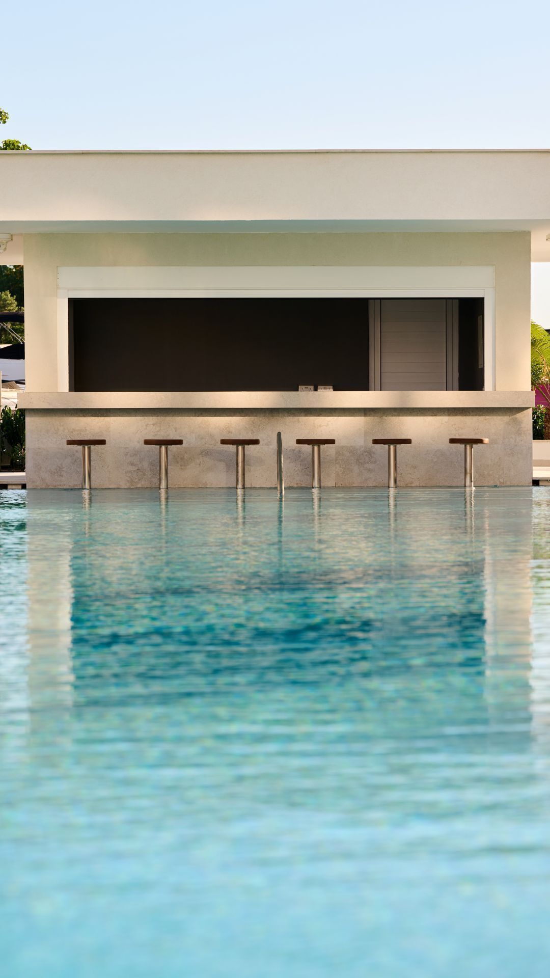 A modern building with a pool in front.