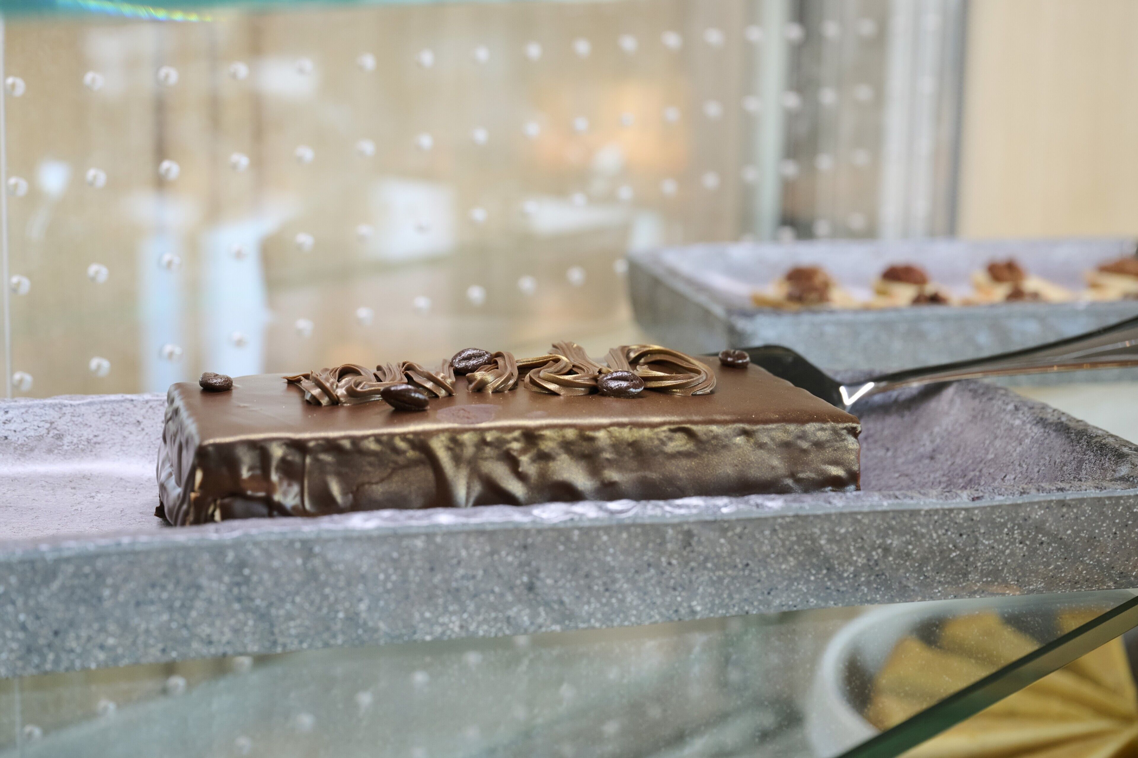 A dessert display with chocolate-covered items and nuts.